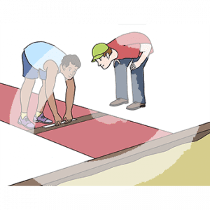 Eine Person mit Sportkleidung steht an der Absprunglinie auf einer Laufbahn. Dahinter ist eine Sandgrube. Naben der Bahn steht eine weitere Person und guckt gebückt auf die Absprunglinie.