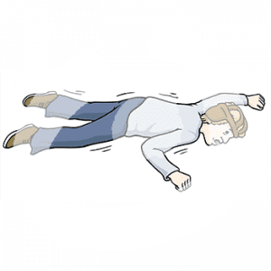 Eine zitternde Person mit Kopfschutz liegt auf dem Bauch am Boden.