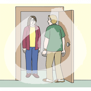 Eine Person steht in einer Tür, davor steht eine andere Person.