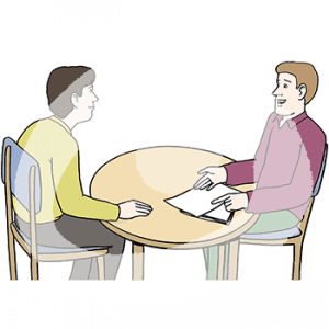 Zwei Männer mit heller Hautfarbe sitzen an einem Tisch. Eine Person zeigt auf zwei Zettel.