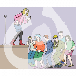 Eine Person mit Mikrofon in der Hand steht auf einer Bühne. Sie guckt zu einer Gruppe tanzender Menschen runter.