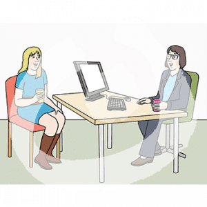 Eine Frau mit Becher in der Hand sitzt hinter einem Schreibtisch mit Computer. Davor sitzt eine weitere Frau mit Becher in der Hand.