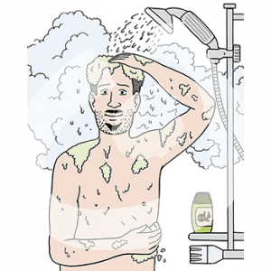 Ein Mann mit nacktem Oberkörper unter einer Duschbrause. Er schäumt sich ein.