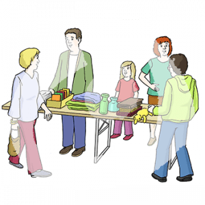 Zwei Erwachsene und ein Kind stehen hinter einem Tisch mit verschiedenen Gegenständen. Davor steht eine Person und eine andere Person läuft vorbei.