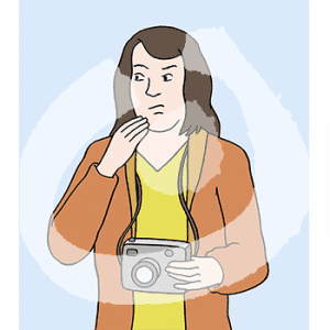 Eine nachdenkliche Frau in Portraitansicht mit Kamera um den Hals. Sie hebt eine Hand ans Kinn.