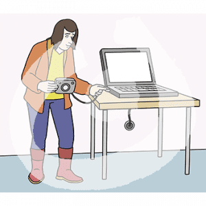 Eine Frau verbindet mit einem Kabel eine Kamera mit einem Laptop.