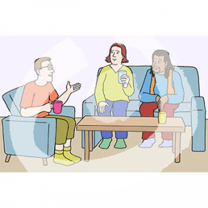 Zwei Personen sitzen auf einem Sofa. Sie gucken zu einer dritten Person auf einem Sessel. Alle haben Becher.