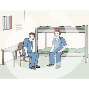 Zwei Personen in Sträflingskleidung gucken sich an. Eine sitzt auf einem Stockbett, die andere auf einem Stuhl. Das Fenster ist vergittert.