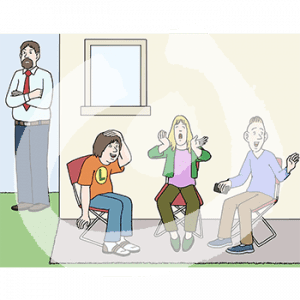 Drei lachende Personen auf Stühlen sitzen nebeneinander vor einem Gebäude. Im Hintergrund steht ein wütender Mann.