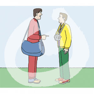 Zwei Personen stehen sich gegenüber. Die Person in roter Trainingsjacke zeigt auf den Gips Arm der Person in gelber Trainingsjacke.