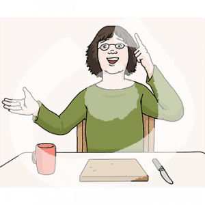 Eine fröhliche Person sitzt an einem Tisch. Vor ihr sind ein Brett und ein Becher. Sie hält einen Finger in die Luft.