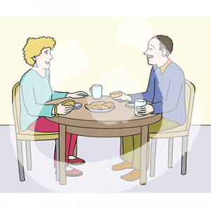 Zwei Personen sitzen sich mit Tassen und Gebäck an einem Tisch gegenüber.