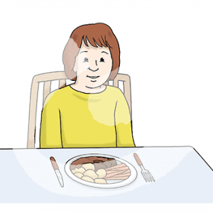 Ein Kind sitzt an einem Tisch vor einem Teller mit Essen.