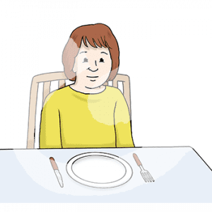 Ein Kind sitzt an einem Tisch vor einem Teller ohne Essen.