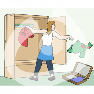 Eine Frau steht vor einem Kleiderschrank. Sie hat ein Shirt in der Hand, unter der anderen fliegt ein anderes Shirt. Hinter ihr liegt ein Koffer.