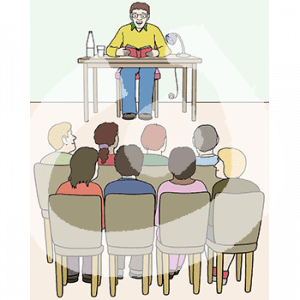 Acht Personen sitzen auf Stühlen und gucken nach vorne. Dort sitzt eine Person an einem Tisch und guckt in ein Buch.