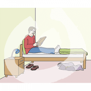 Ein weinender Mann sitzt auf einem Bett und guckt ein Bild an.