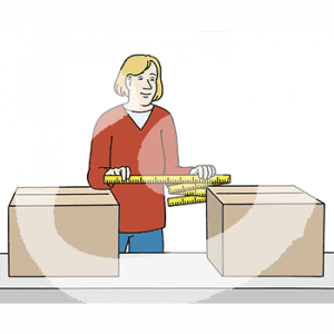 Eine Person steht vor einem Tisch mit zwei Kartons. Sie hält einen Zollstock über die Lücke zwischen den Kartons.