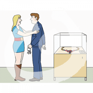 Ein Mann in Wärteruniform mit Schlüsselbund und eine Frau stehen neben einer Glasvitrine. Darin ist eine Kette. Sie hält ihn an den Schultern fest.