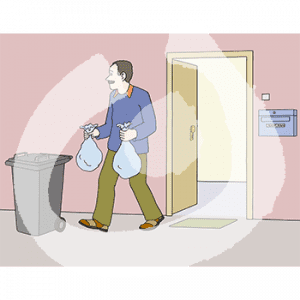 Eine Person geht von einer Tür in Richtung einer Mülltonne. In den Händen trägt er zwei Müllbeutel.