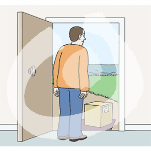 Ein Mann steht in einer offenen Tür. Davor steht ein Paket.