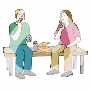 Zwei Personen sitzen mit Becher und Essen in der Hand auf einer Bank. Darauf steht eine Kanne und eine Brotdose.