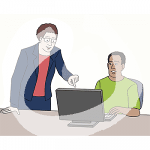 Eine Person sitzt vor einem Computer. Daneben steht eine Person und zeigt auf den Bildschirm.