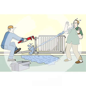 Eine Person in Blaumann hält eine Zange über dem Rohr einer Heizung. Davor ist eine Pfütze. Aus dem Rohr kommt ein Wasserstrahl und sprüht in das Gesicht einer anderen Person daneben.