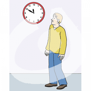 Eine Person guckt auf eine Uhr an der Wand.