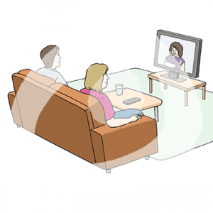 Zwei Personen sitzen auf einem Sofa und gucken Fernsehen.