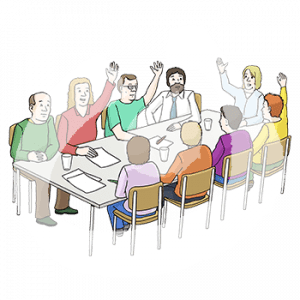 Neun Personen sitzen an einem Tisch mit Zetteln und Stiften. Vier heben einen Arm.