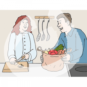 Eine Person in Kochjacke steht vor einer Arbeitsfläche und schneidet Gemüse. Neben ihr steht eine weitere Person in Alltagskleidung und hält einen Sack mit Gemüse.