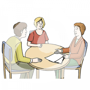 Ein Mann und zwei Frauen mit heller Hautfarbe sitzen an einem Tisch. Eine Frau zeigt auf zwei Zettel.