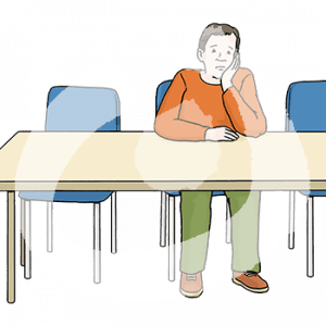 Eine traurige Person sitzt mit aufgestütztem Kopf alleine an einem Tisch.