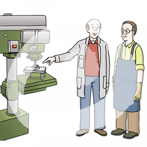 Eine Person mit grauem Kittel zeigt auf eine Standbohrmaschine. Neben ihr steht eine Person in Schürze und Handschuhen.