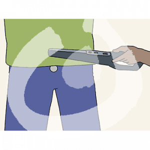 Eine Hand hält einen Metalldetektor an einen Hosenbund.