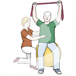 Eine Person sitzt auf einem Gymnastikball. Sie streckt ihre Arme mit einem Fitnessband über dem Kopf. Eine weitere Person kniet daneben und hält Bauch und Rücken fest.