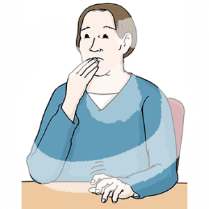 Eine nervöse Person sitzt an einem Tisch und hält sich die Hand an den Mund.