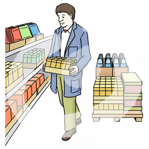 Eine Person in einem Kittel mit einer Kiste Produkte auf dem Arm. Sie steht vor einem Regal mit Produkten. Dahinter steht eine Palette mit Produkten.