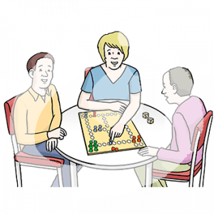 Drei Personen sitzen um einen Tisch mit einem Brettspiel.