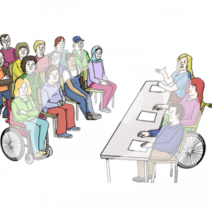 Personen sitzen in Stuhlreihen und gucken nach vorne. Dort sitzen drei Personen mit Zetteln vor sich an einem Tisch.