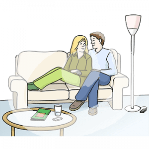 Zwei Personen sitzen Arm in Arm auf einem Sofa.