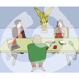 Eine Person sitzt an einem Schreibtisch und guckt zwei Personen an die ihr gegenüber sitzen. Im Hintergrund ist eine goldene Engelsstatue.