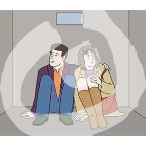 Zwei ängstliche Personen sitzen Arm in Arm in einem dunklen Raum.