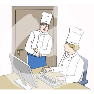 Eine Person in Kochjacke, Schürze und Kochmütze steht vor einem Schreibtisch und hält schmerzverzerrt beide Hände auf dem Bauch. Eine weitere Person in Kochjacke und Kochmütze sitz vor einem Computer und guckt zu der ersten Person hoch.