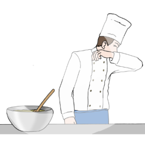 Eine Person in Kochuniform, Schürze und Kochmütze steht vor einem Tisch mit einer Schüssel Lebensmittel, hat den Kopf gedreht und hält Nase und Mund in ihre Armbeuge