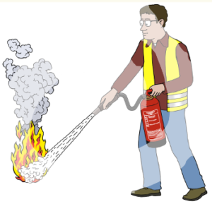 Ein Mann hat einen Feuerlöscher in der Hand und sprüht damit auf eine brennende Stelle am Boden.