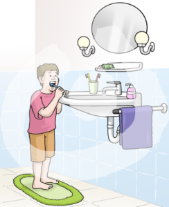 Ein Kind steht vor einem Waschbecken und hat eine Zahnbürste im Mund.