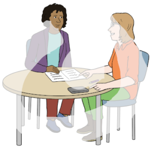 Zwei Personen sitzen an einem Tisch. Eine Person hat eine dunkle Hautfarbe. Die andere Person hat eine helle Hautfarbe. Sie zeigt auf ein aufgeschlagenes Heft auf dem Tisch.