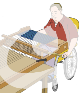 Eine Person sitzt im Rollstuhl vor einem Webstuhl.